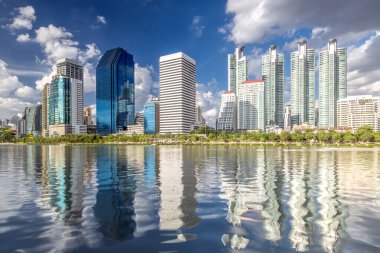 Bangkok, Tayland 'daki Benjakiti parkında mavi gökyüzü ve nehri olan Kule şehri, kondomenyum ve kabarıklık.