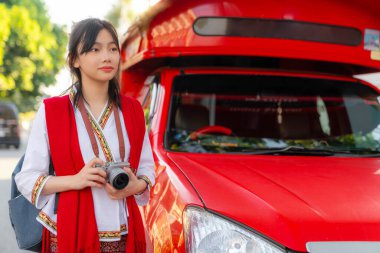 Asyalı kadın gezgin. Geleneksel olmayan kırmızı elbise. Chiang Mai şehrindeki eski tapınakta seyahat ediyor.