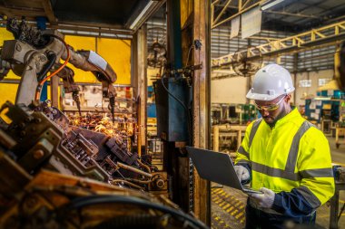 Afrika kökenli Amerikalı işçiler, robot otomobil kaynak makinesi bölümünde ve montaj için kaynak yapan Amerika Birleşik Devletleri 'ndeki eski devlet fabrikasında çalışıyorlar.