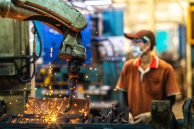 Robot otomobil kaynak makinesi bölümündeki eski Çin fabrikasında çalışan Asyalı işçiler ve montaj için kaynak, Çin