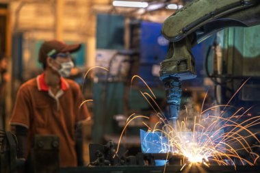 Robot otomobil kaynak makinesi bölümündeki eski Çin fabrikasında çalışan Asyalı işçiler ve montaj için kaynak, Çin