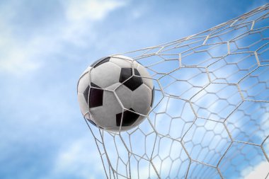 Top kalede net arka planda, futbolcu sayı yapmak için deri bir ayak topu atıyor.