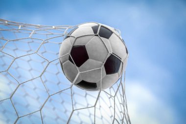 Top kalede net arka planda, futbolcu sayı yapmak için deri bir ayak topu atıyor.