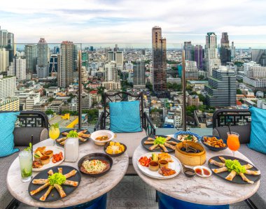 Mahanakhon binası ve Bangkok şehir manzaralı, Bangkok, Tayland manzaralı çatı restoranındaki masada Çin yemeği var.