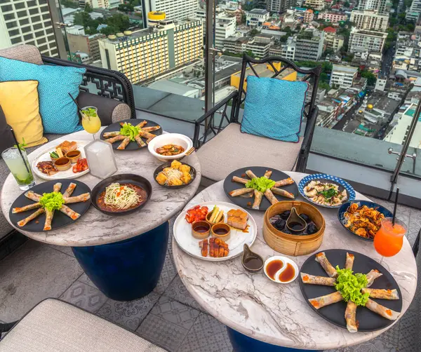 chinese food on the table in rooftop restaurant with mahanakhon building and Bangkok city view, bangkok, Thailand