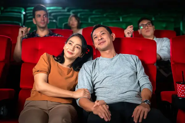 アジアのカップルの幸せな旅行 スイートシート赤い座席に座って 手でポップコーンを楽しんで映画を見て 人々は週末にリラックスして休日のアクティビティ ストック画像