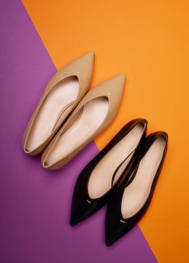 Farklı renklerde ama parlak kontrast arka planda aynı model olan iki çift kadın başparmak bale ayakkabısı. Üst manzara, düz yatış. Ayakkabı ile yaratıcı minimalist yerleşim.