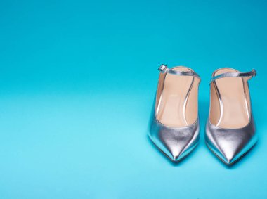 Parlak, parlak, mavi bir arka planda izole edilmiş, sivri uçlu kadın ayakkabıları. Ön manzara, kopyalama alanı. Moda konsepti