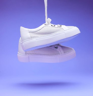 Modern moda beyaz delikli ayakkabılar renkli arka planda ayakkabı bağcıklarına tutunur. Kapatın. Sıradan ayakkabılar, spor ayakkabılar. Fitness, spor, eğitim konsepti.