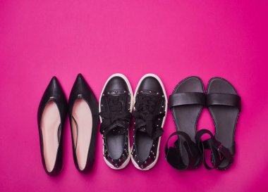 Beyaz fuşya arka planında üç çift şık siyah yaz ayakkabısı. Düz konum, üst görünüm, üstteki boşluğu kopyala. Reklamcılık, moda blogu veya dergi konsepti. Etkinlik için ayakkabı seçmek.