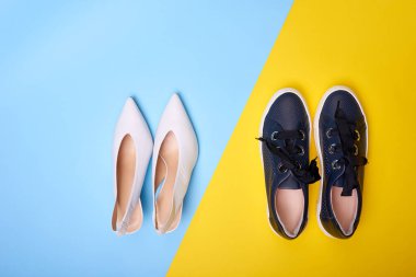 Geometrik iki renkli arka planda farklı renkte ve stilde iki çift kadın ayakkabısı. Üst manzara, düz yatış. Yaşam tarzı, ayakkabı seçme kavramı..