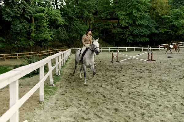 女骑手在竞技场练习骑马 作为礼物 女孩在河马场上骑马课 骑在背上的骑马的人 海马疗法 — 图库照片