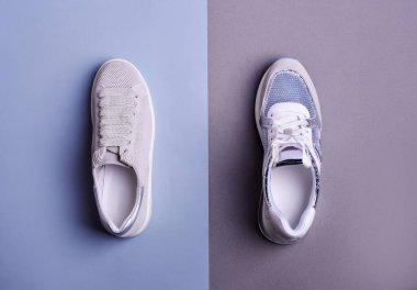 İki farklı spor ayakkabısının üst görünümü iki renkli arka plan, gri ve mavi renk şeması. Moda spor ayakkabıları. Yaratıcı minimalist düzen. İndirim, sezon satışları.