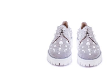 Fotokopi alanı olan beyaz arka planda izole edilmiş incilerle süslenmiş beyaz kurdeleli kadın ayakkabıları. İndirim, sezon satışları. Perakende, mağaza, butik.