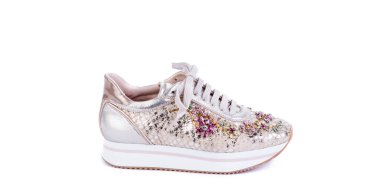 Pembe malzemeden yapılmış kalın bir kadın ayakkabısı, balık pullarını taklit ediyor, beyaz arka planda çok renkli bir yapay elmasla süslenmiş beyaz kurdeleli tabanı var. Moda fotoğrafçılığı.