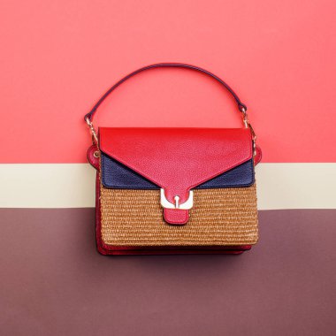 Kırmızı ve siyah deri kapaklı modern kadın el çantası, altın donanım ve üst kulpu kopya alanı olan çok renkli yaratıcı bir arka planda izole edilmiş. Reklam afişi. Moda blogcusu içeriği.