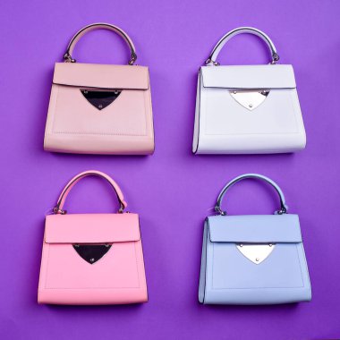Aynı tasarıma sahip ama mor arka planda farklı renkte dört adet modaya uygun deri kadın çantası vardı. Moda blogu ya da dergisi. Bir etkinlik için çanta seçmek. Moda aksesuarları.