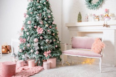 New Year's interior design. Lush Christmas tree with pink and silver ornaments. Pink boxes of gifts and a rug, a velour pink sofa with a fluffy pillow. A fireplace with cute Christmas decorations. clipart