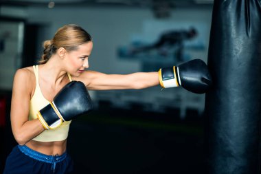 Spor salonunda kadın kum torbası eğitimi, fitness konsepti