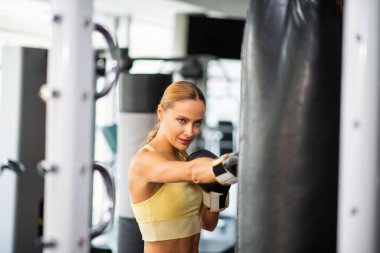 Spor salonunda kadın kum torbası eğitimi, fitness konsepti