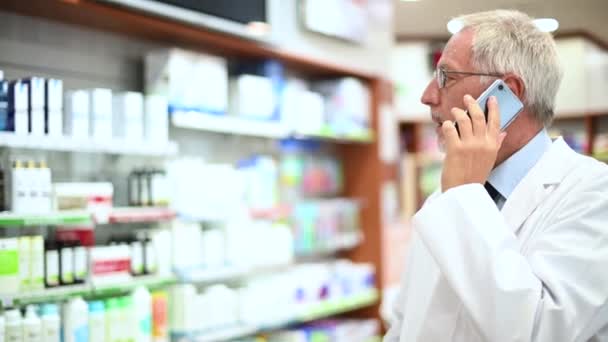 Farmacêutico Falando Telefone Com Cliente Sua Loja Verificando Produto — Vídeo de Stock