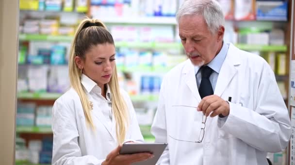 Dwóch Farmaceutów Rozmawia Podczas Pracy Tablecie Swoim Sklepie — Wideo stockowe