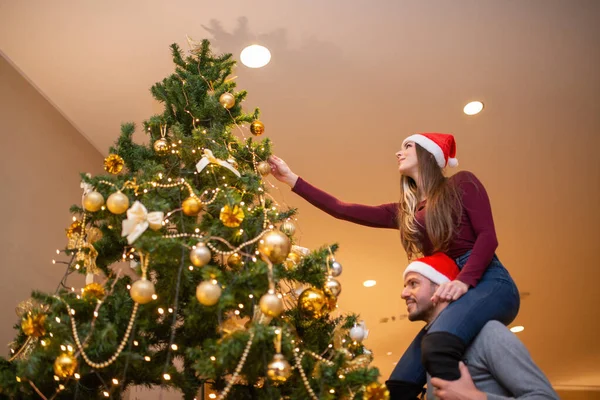 Pár Santa Klobouky Příprava Vánoční Strom — Stock fotografie