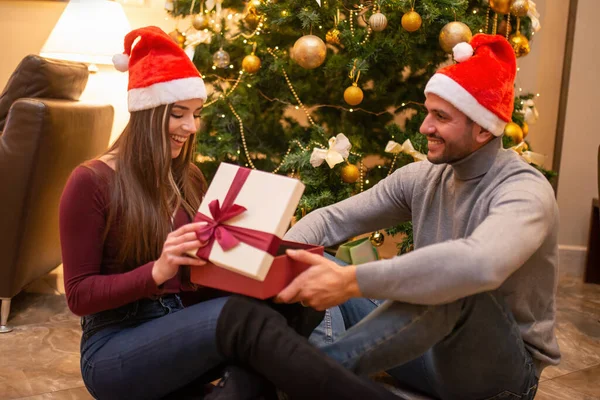 Genç Çift Noel Ağacının Yanında Hediye Açıyor — Stok fotoğraf