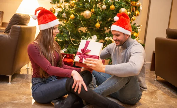 Genç Çift Noel Ağacının Yanında Hediye Açıyor — Stok fotoğraf