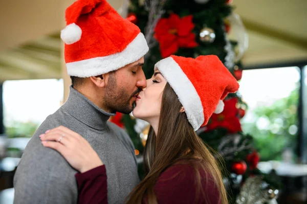 Schönes Paar Küsst Und Trägt Einen Weihnachtsmannhut — Stockfoto