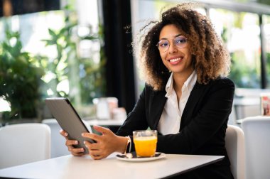 Genç Afro Amerikalı iş kadını portakal suyu molası verdi.