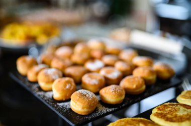 Closeup of pancakes donuts on a buffet in a luxury restaurant