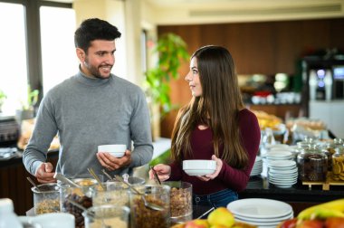 Couple picking food at a buffet in a hotel for his breakfast