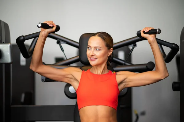 Athletic Woman Trains Shoulders Machine Gym — Zdjęcie stockowe