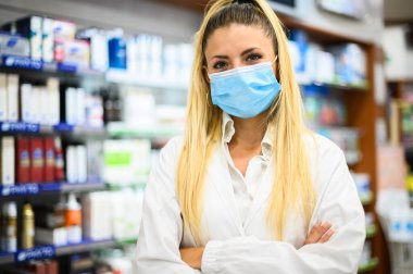 Eczanede çalışan koruyucu maskeli bir kadın eczacı. Tıbbi sağlık hizmeti kavramı.