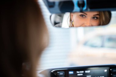 Arabasını kullanan genç bayan dikiz aynasından yansıdı.