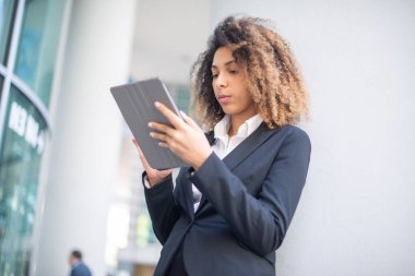 Genç Afrikalı Amerikalı kadın dijital tablet kullanıyor.