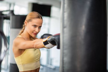 Spor salonunda kadın kum torbası eğitimi, fitness konsepti