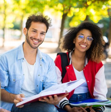 Bir grup üniversite öğrencisi parkta birlikte okuyorlar.