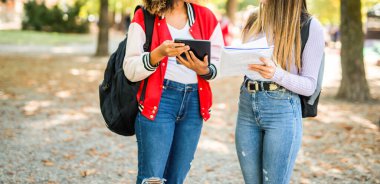 Bayan üniversite öğrencileri üniversitelerinin yakınındaki bir parkta birlikte okuyorlar.