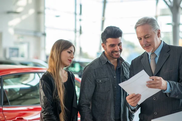Fiatal Család Beszél Eladóval Kiválasztják Autójukat Bemutatóteremben — Stock Fotó