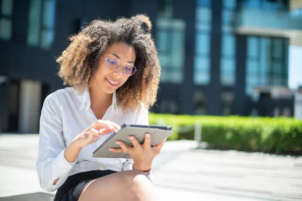 Afro-Amerikan iş kadını iş ortamında dijital tabletini açık havada kullanıyor.