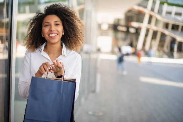 若い笑顔のアフリカ系アメリカ人女性がショッピングバッグを持って — ストック写真