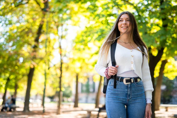 大学の近くの公園で屋外を歩く笑顔の女子大生 — ストック写真