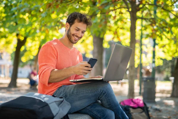 Joven Hombre Sonriente Usando Una Computadora Portátil Aire Libre —  Fotos de Stock
