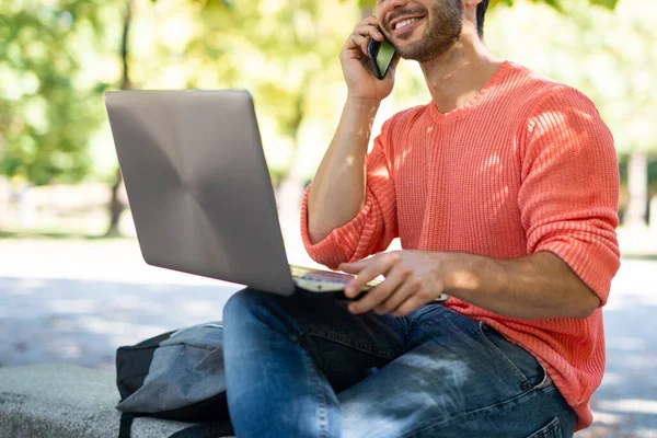 Junger Mann Mit Laptop Park Während Mit Seinem Handy Spricht — Stockfoto