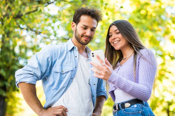 Glimlachende Man Tonen Van Zijn Mobiele Telefoon Aan Zijn Vriendin — Stockfoto