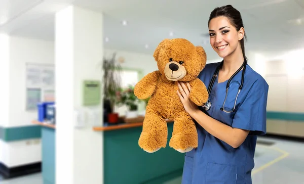 テディベアを持った美しい看護師 小児科医のコンセプト — ストック写真