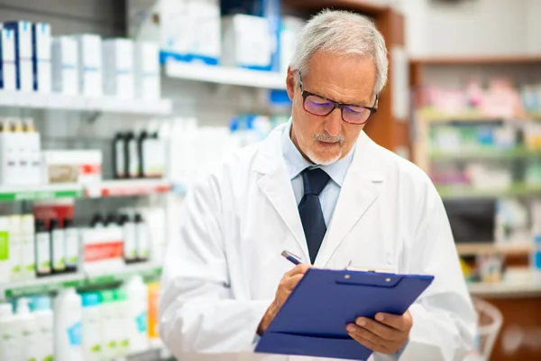 Ανώτερος Φαρμακοποιός Γράφει Ένα Έγγραφο Ενώ Στέκεται Στο Pharmac Του — Φωτογραφία Αρχείου