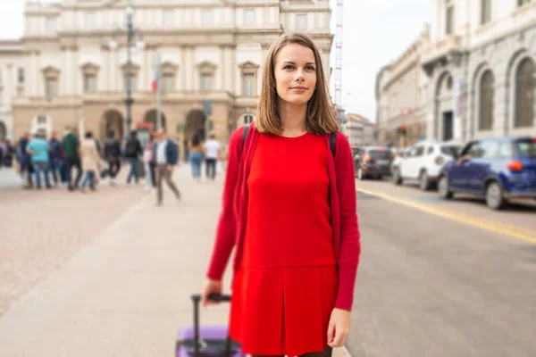 大都市で彼女のスーツケースと一緒に歩く女性 — ストック写真